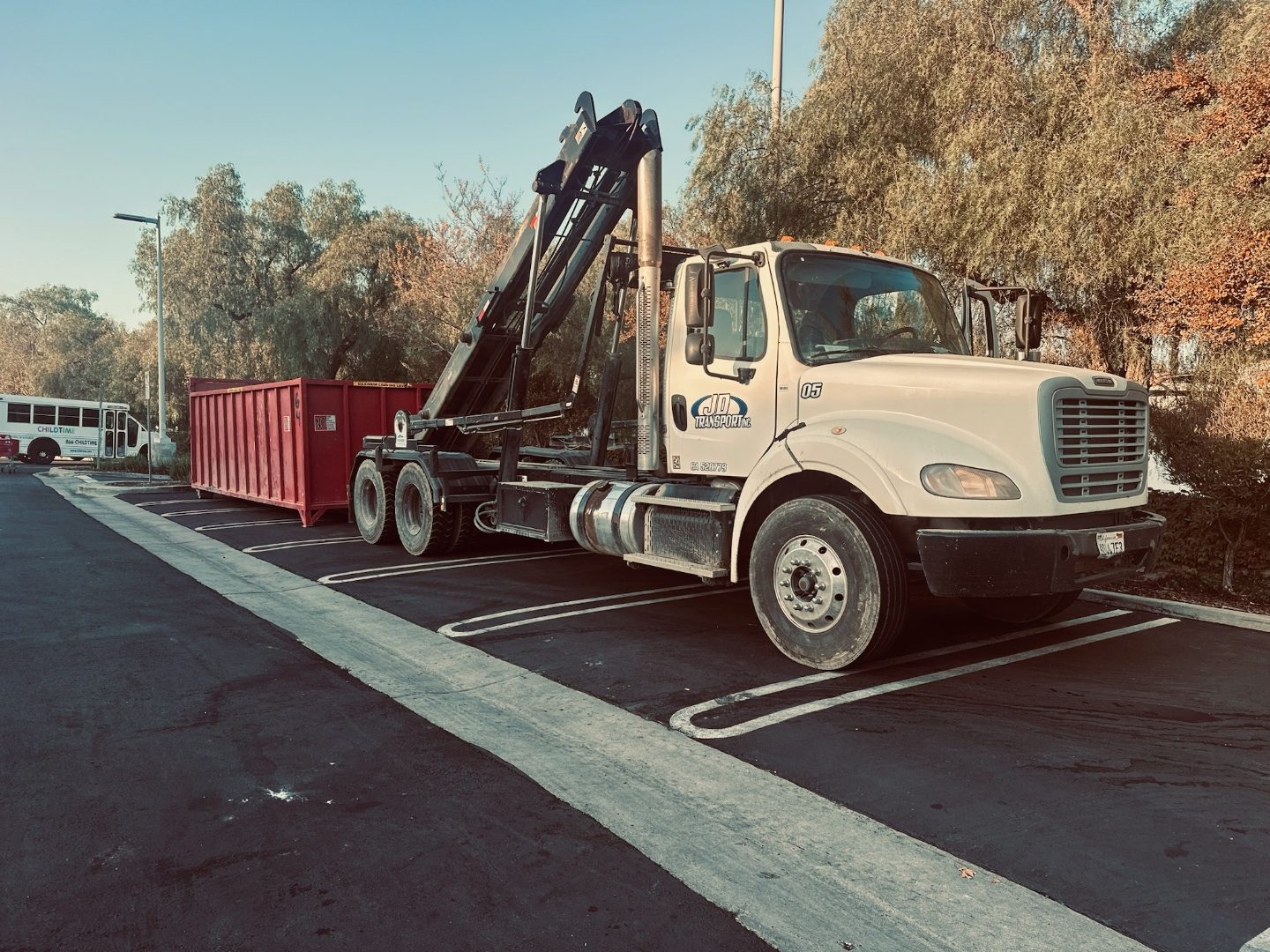 Construction debris being loaded into a JD Roll Off Dumpsters container on a C&D job site