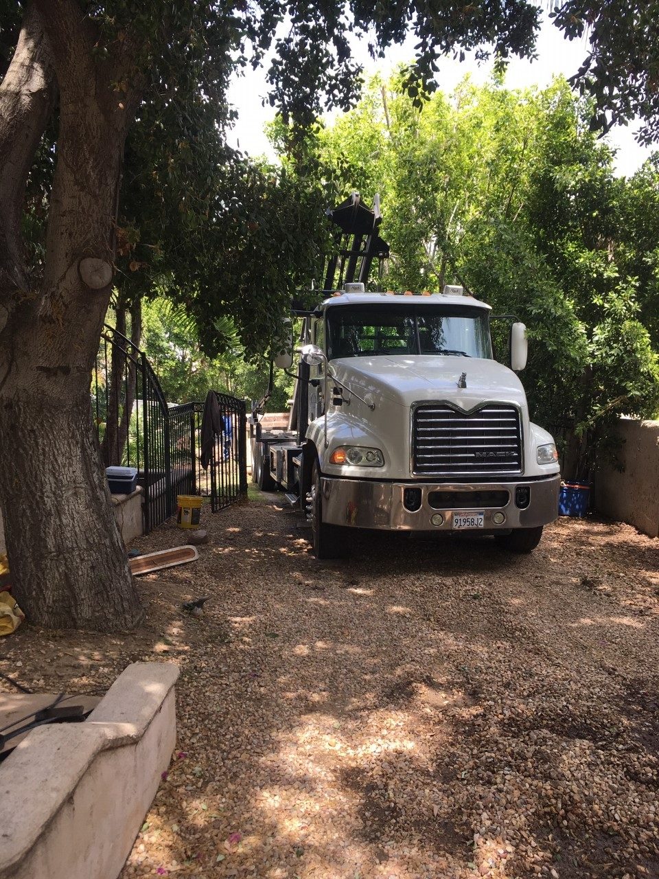 JD Roll Off Dumpsters truck delivering a roll-off container to a Riverside driveway